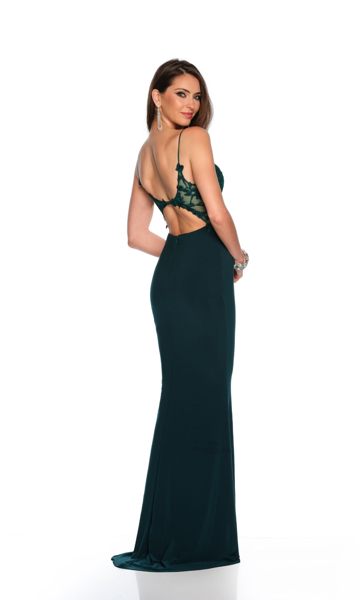 A woman models the Dave & Johnny Long Prom Dress 11659—a fitted, dark green formal gown with thin straps, v-neck, and open back—standing slightly turned on a white background.